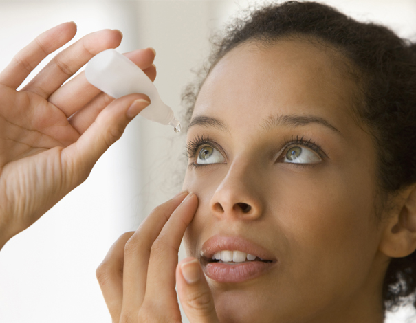 Woman putting in eye drops