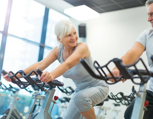senior woman on stationary bike senior woman on stationary bike