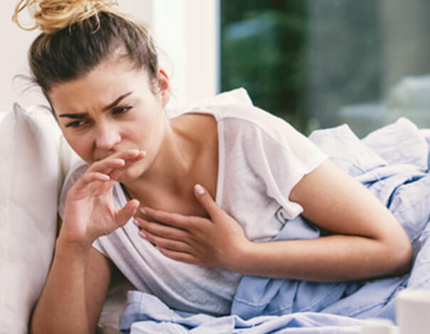 young woman caughing woman caughing in bed
