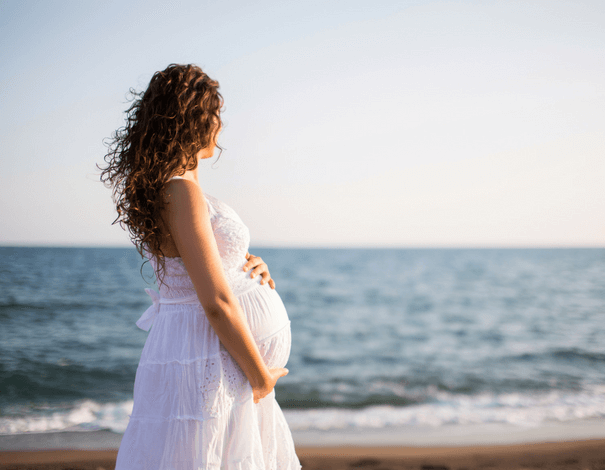 Femme enceinte de dos sur la plage  Femme enceinte de dos sur la plage