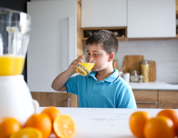 enfant buvant jus d'orange pour prévenir le rhume