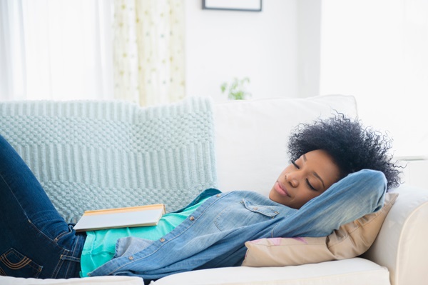 Femme étendue sur un canapé qui fait une sieste